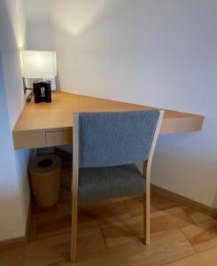 een houten bureau met een stoel en een lamp bij 那須 にごり湯の大浴場露天風呂があるホテルコンドミニアム in Nasu-yumoto