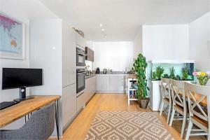 a living room with a kitchen and a dining room at The Harbour- Stylish spacious family sized apartment in London