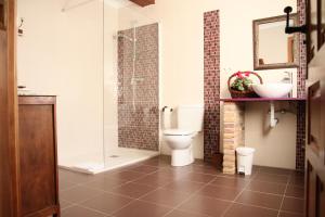 a bathroom with a toilet and a glass shower at Agroturismo "La Bardena Blanca II" in Arguedas