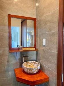 a bathroom with a sink and a mirror at Hoi An Ngo Homestay in Hoi An