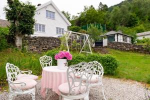 una mesa con sillas y una mesa con flores rosas en Historisk sjarm - moderne komfort 10min fra Bergen, en Bergen