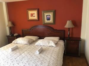 een slaapkamer met een bed met 2 kussens erop bij Hotel Las Condes in Trujillo