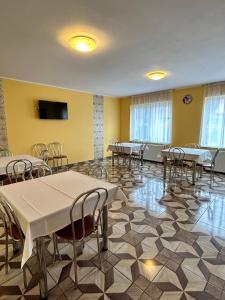 a room with tables and chairs and a flat screen tv at Kelemen Vendégház 2 in Praid