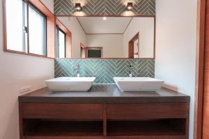 a bathroom with two sinks and a large mirror at じぇーむすのおうち in Yawatano