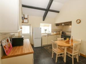 a kitchen with a table and a kitchen with a refrigerator at Ty Hen in Pwllheli