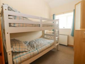 a bedroom with two bunk beds and a window at Ty Hen in Pwllheli