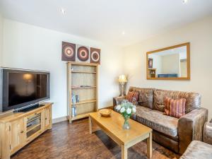 a living room with a couch and a tv at The Hayloft - Uk44519 in Tetney