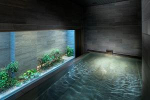 京都DoubleTree by Hilton Kyoto Higashiyama的一座带水族馆的别墅内的游泳池