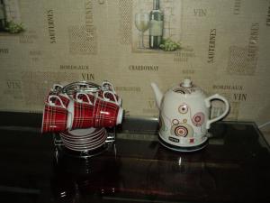 a tea kettle and a stack of plates on a table at Apartment on Vasylia Stusa St, 10 in Bila Tserkva