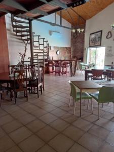a dining room with tables and chairs and a staircase at Die Windpomp Guesthouse in Gobabis