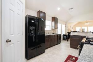 una cocina con una gran nevera negra. en Select Exclusive Room in Fresno Texas, en Fresno 18 fotos más