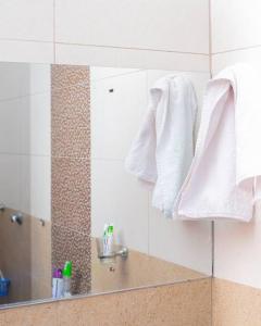 La salle de bains est pourvue de serviettes blanches suspendues sur un miroir. dans l'établissement Forget your worries in this serene 5 Bedroom Villa in Ngong, à Nairobi