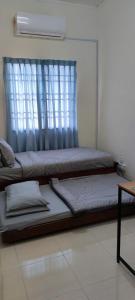 a large bed in a room with a window at As-Salam Homestay in Sungai Petani