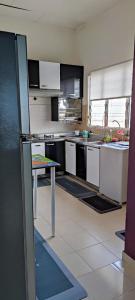 a kitchen with white cabinets and a table in it at As-Salam Homestay in Sungai Petani