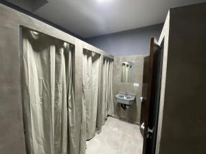a bathroom with shower curtains and a sink at Urban Jungle Hostel in San Miguel de Tucumán