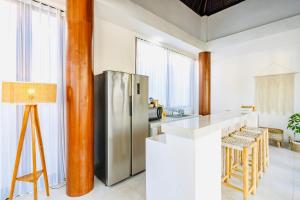 a kitchen with a stainless steel refrigerator and a counter at Casa Canguro Villa in Nusa Lembongan