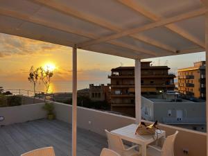 a cat sitting on a table on a balcony with the sunset at La Piazza BeB in Tropea