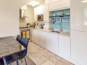 a kitchen with white cabinets and a table at Springhill Court in Bewdley