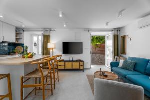 una cucina e un soggiorno con divano blu di Nona Vi - Boutique Stone House a Bol