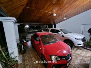 un coche rojo estacionado en un garaje con un camión en Departamentos las chacras en Juana Koslay 