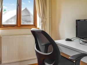 biuro z biurkiem z komputerem i krzesłem w obiekcie Swift Cottage w mieście Chilton Polden 