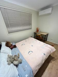 a bedroom with two stuffed animals on a bed at Cosy 3 bedroom family home near beach and shops in Frankston