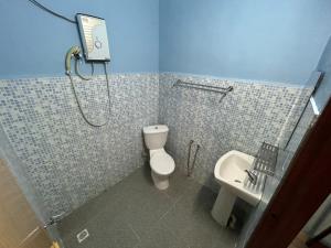 un bagno con doccia, WC e lavandino di Dtahan Motel Taman Negara a Kuala Tahan