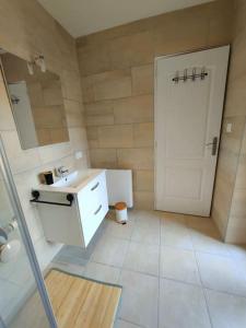 baño con lavabo blanco y puerta blanca en Martin Appartement Cambrai avec cour, en Cambrai