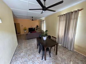 a living room with a table and a ceiling fan at Dtahan Motel Taman Negara in Kuala Tahan