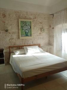 a bed in a bedroom with a painting on the wall at B & B Monte Adamo in Conversano