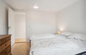 a white bedroom with a large bed and a wooden dresser at Nice Apartment In Sams With Wifi in Onsbjerg