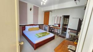 sypialnia z łóżkiem i telewizorem w obiekcie Ngoc Son Hotel w mieście Bien Hoa
