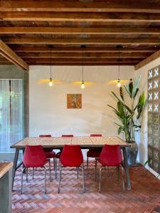 a large table with red chairs in a room at Dontrei Villa Angkor in Siem Reap