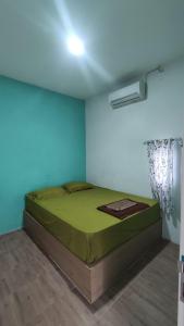a bedroom with a green bed in a room at Rumah Teman Hostel in Semarang