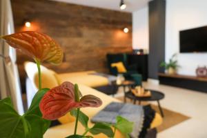 sala de estar con sofá amarillo y flor roja en La Villetta, en Bale