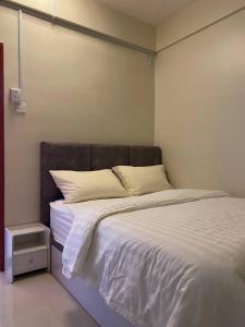 ein Schlafzimmer mit einem großen Bett mit weißer Bettwäsche in der Unterkunft Shanin's Homestay in Kuala Terengganu