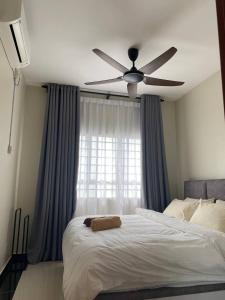 a bedroom with a bed with a ceiling fan at Shanin's Homestay in Kuala Terengganu