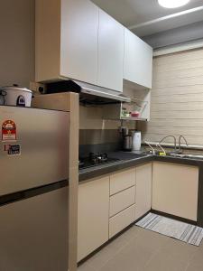 a kitchen with white cabinets and a stainless steel refrigerator at Shanin's Homestay in Kuala Terengganu