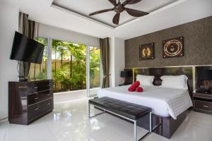 1 dormitorio con 1 cama grande y TV en Three-Level Spacious Villa Dragon C, 4BR, Pool & Terrace, en Ban Klang