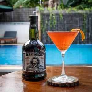 a bottle of pressure island and a drink on a table at Habana Angkor Boutique Hotel in Siem Reap