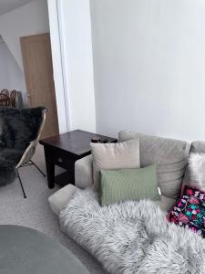 a living room with a couch with a fur rug at Coetmor Cottage in Llanfairfechan