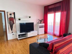 uma sala de estar com um sofá e uma televisão em Three Roses em Split