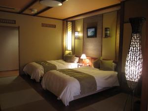 Кровать или кровати в номере Inatori Tokai Hotel Yuen