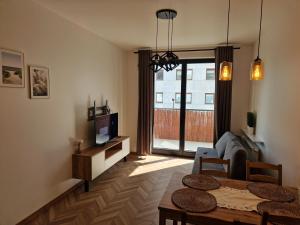 a living room with a couch and a table and a tv at Warsaw-Aparts Sokratesa in Warsaw
