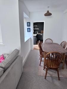 een woonkamer met een tafel en stoelen en een bank bij Coetmor Cottage in Llanfairfechan