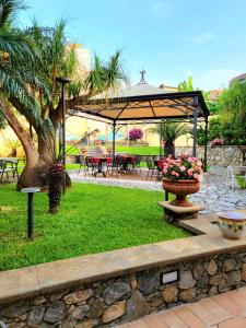 a park with a pavilion and a table with flowers in the grass at Hotel Garibaldi in Milazzo