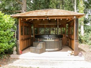 a wooden gazebo with a hot tub in it at The Old Stable in Conwy