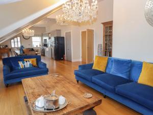 een woonkamer met twee blauwe banken en een tafel bij 7 Four Seasons in St Ives