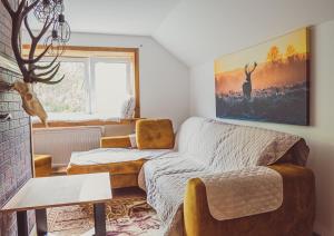 a living room with a couch and a window at Gajówka na Roztoczu in Lubycza Królewska +9 photos