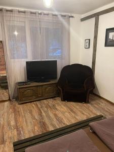 Il comprend un salon avec une chaise et une télévision à écran plat. dans l'établissement Hot Spot Studio in the center, à Sofia